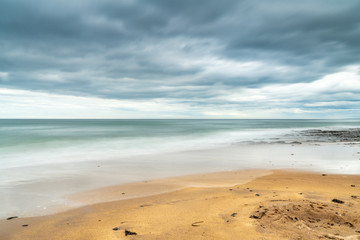 Dramatic sky over a beach, seen at Cocklawburn Beach near Berwick-upon-Tweed in Northumberland, England, UK