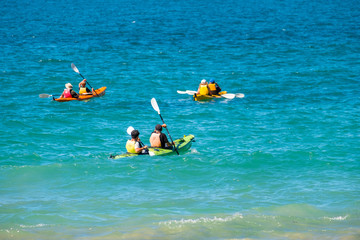 Poeple doing kayaking in the blue ocean.