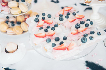 Sweet background. Eclairs with strawberries and blueberry. Candy Bar. Delicious sweet buffet.