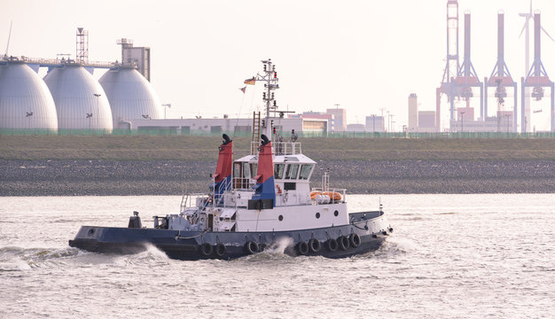 Hafenschlepper auf dem Weg zu einem Containerschiff um es zu schleppen 