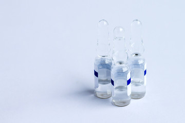 Medical ampoules on a blue background. Vaccine in glass medical ampoules on a blue background. Medical ampoules