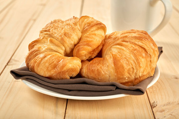 fresh baked croissants on wooden table