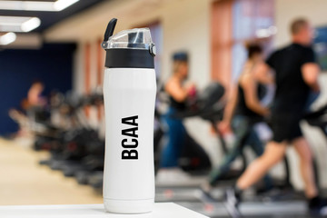 Plastic bottle or cup with BCAA fitness drink close up
