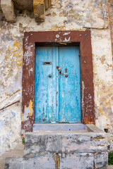 Fototapeta na wymiar Beautiful old, light blue painted, weathered, locked door of an abandoned building at Rabat, Malta