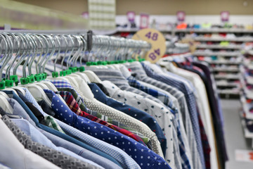 Elegant shirts on hangers in the store blurred. On the eve of Black Friday. Background for design from a department store.