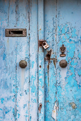 Detail of a beautiful old, light blue painted, weathered, locked door of an abandoned building at Rabat, Malta