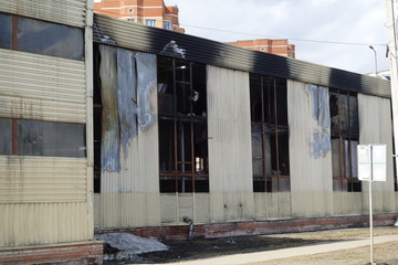 Multi-storey parking after a fire. Copy-darkened windows with burned out cars inside