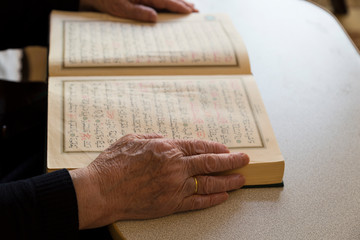 Naklejka premium the old woman reading Quran. Holy book Koran for Muslims holiday, Ramadan,blessed Friday message .