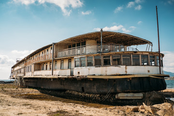 Old vintage abandoned rusted ship run aground after shipwreck accident in beginning of XX century in Crimean coast on sand beach