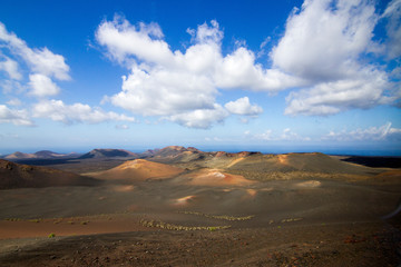 Fototapeta na wymiar Panoramic view of Lanzarote volcanic island with blue cloudy sky