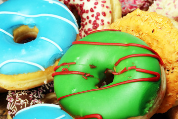 assorted donuts with chocolate frosted, pink glazed and sprinkles donuts.
