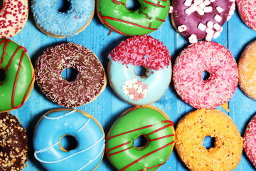 assorted donuts with chocolate frosted, pink glazed and sprinkles donuts.