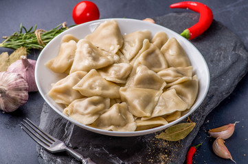 boiled dumplings with filling and sauce on the plate. Steam over a plate