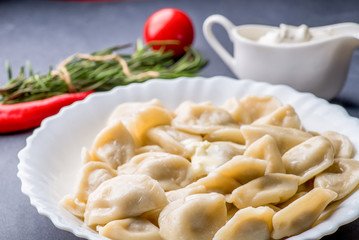boiled dumplings with filling and sauce on the plate. Steam over a plate