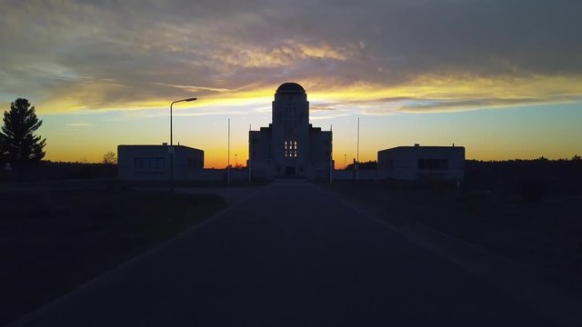 Dolly shot along the way leading towards the abandoned building Radio Kootwijk during sunset.