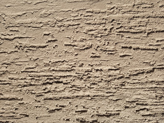 The texture of the stone wall painted with dry brown plaster.