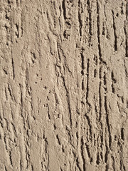 The texture of the stone wall painted with dry brown plaster.