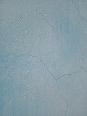Texture of the old cracked wall. The wall is painted pale blue paint.