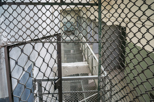 Old prison corridor with open cells.	