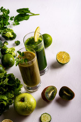 Green smoothie kiwi and cauliflower drinks on white wooden background. Raw food and drink. Flat lay.