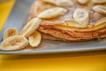 Honey or maple syrup over crepes. Close up of thin pancakes, blini or crepes with honey