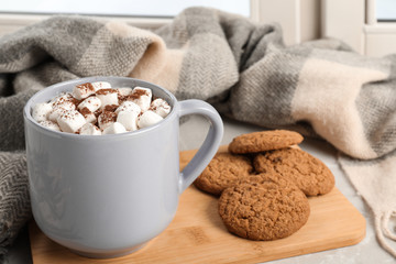Composition with cup of cocoa and cookies on windowsill. Winter drink
