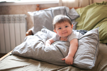 funny shaggy baby on bed with pillow, waking up