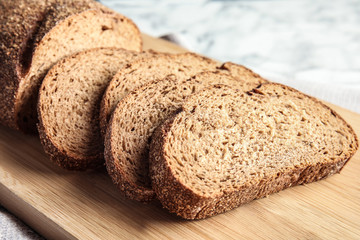 Tasty sliced bread on wooden board, closeup