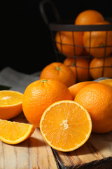 Wooden board with ripe oranges on table. Space for text