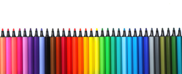 Many colorful markers on white background, top view. Rainbow palette