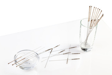 Silver needles for traditional Chinese acupuncture medicine. White background.