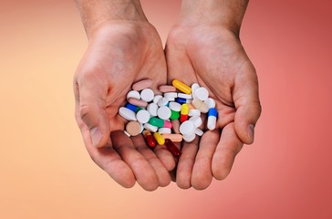 Girl eating lots of pills on background