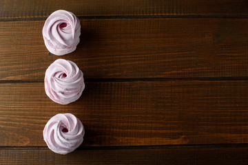 Pink Meringue Marshmallow Zephyr On Wooden Brown Background.Top view. Pink sweet homemade zephyr or...