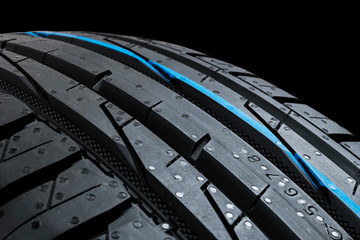 Set of summer car tires on black background. Tire stack background. Car tyre protector close up....