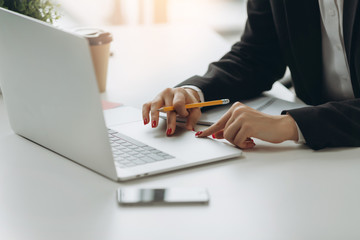 Closeup image of hand using and touching on laptop touchpad on table. Working in modern office.