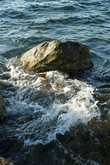 The wreckage of rocks in the sea near the rocky shore.