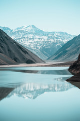 Lago en cordillera, embalse del yeso, cordillera de los andes, montaña nevada con lago turquesa.