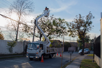 Trabajador cambiando alumbrado publico, renovación de iluminación publica, trabajo municipal.