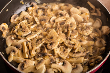 Cooking dishes from sliced mushrooms with spices. Tasty champignons