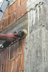 Worker cutting rebar form the concrete with the grinder