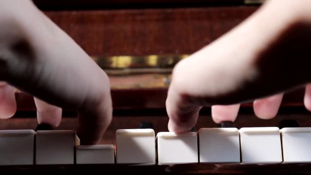 Hands of caucasian woman playing piano, close up, side view