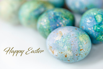 Easter greetings in English. Painted eggs on a light background. Spring and holidays.