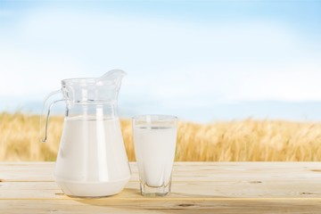 Glass jug of fresh milk  on background