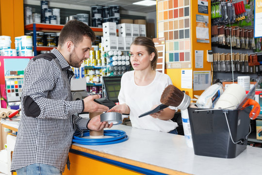Girl seller standing at the counter and consulting  man