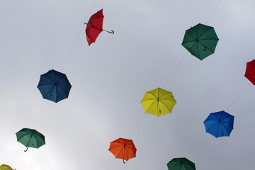 Colored umbrellas floating in the sky
