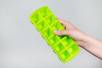 Closeup view of new green empty plastic form for making ice cubes for cocktails. Horizontal color...