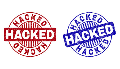 Grunge HACKED round stamp seals isolated on a white background. Round seals with grunge texture in red and blue colors. Vector rubber overlay of HACKED label inside circle form with stripes. © imagecatalog