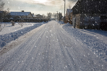 small street in suburbia in winter snowstorm