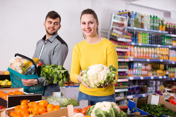 Nice woman with husband looking for vegetables