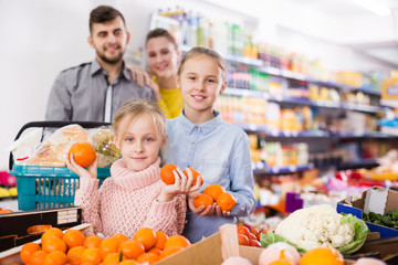 Fototapeta premium sisters during family shopping in greengrocery department